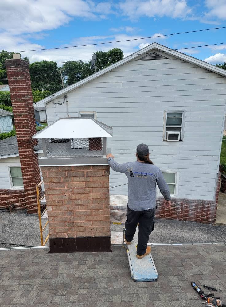 Chimney technician on a roof finishing a custom chimney cap installation and masonry repair in Dundalk